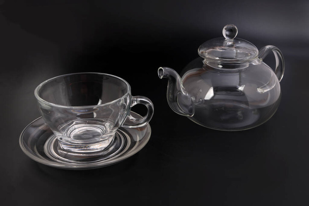 Vidro transparente vazio ver através bule chaleira café xícara de chá pires definido no fundo preto - Foto, Imagem