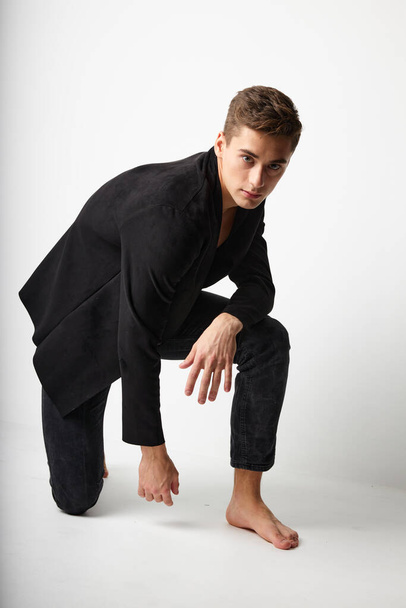 can be built on one knee posing black blazer fashionable clothing modern style - Foto, imagen