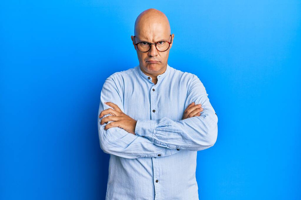 Middle age bald man wearing casual clothes and glasses skeptic and nervous, disapproving expression on face with crossed arms. negative person.  - Photo, Image