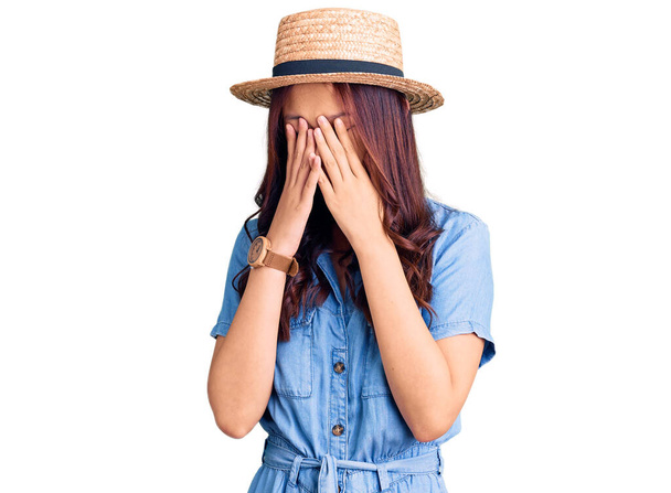 Mladá krásná čínská dívka v letním klobouku tření oči pro únavu a bolest hlavy, ospalý a unavený výraz. problém s viděním  - Fotografie, Obrázek