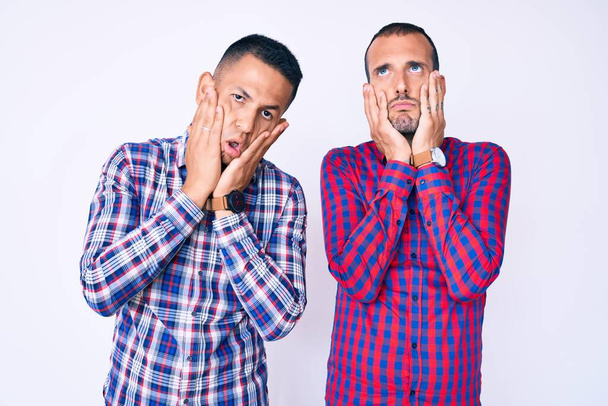 Mladý gayové pár dva muži na sobě ležérní oblečení unavené ruce zakrývající tvář, deprese a smutek, rozrušený a podrážděný pro problém  - Fotografie, Obrázek