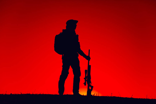 Elite forces sniper patrolling with gun on sunset - Photo, Image