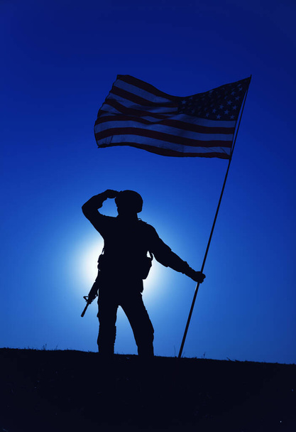 Silhouette of saluting US army soldier with flag - Fotoğraf, Görsel