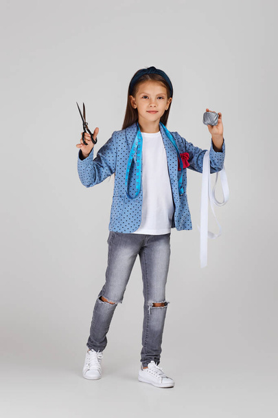 adorable little girl holding tape measure and spool of thread - Fotoğraf, Görsel