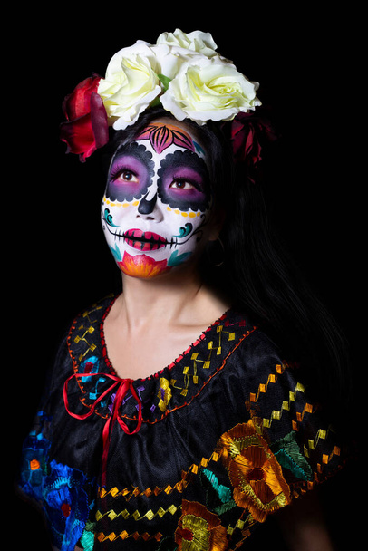 Japanerin trägt Zuckerschädel oder Catrina-Make-up und mexikanische Tracht für eine Porträtfotosession. - Foto, Bild