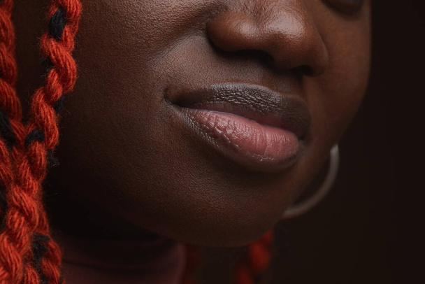 Extreme close up της νεαρής Αφροαμερικανής γυναίκας με πλεγμένα μαλλιά εστίαση σε παχουλά φυσικά εθνοτικά χείλη και χαρακτηριστικά του προσώπου, αντιγραφή χώρου - Φωτογραφία, εικόνα