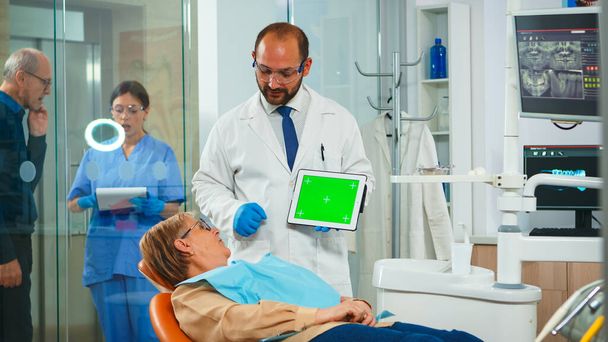 Dentysta wskazujący na zielony ekran - Zdjęcie, obraz