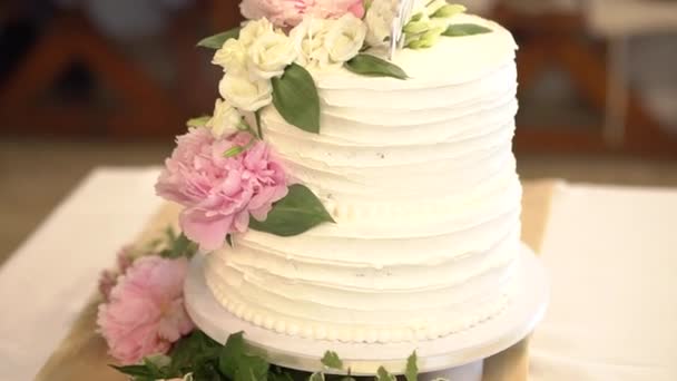 esküvői torta fehér krém, díszített virágok bazsarózsa és liziantusz - Felvétel, videó