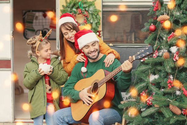 Joyeux famille avec guitare en plein air la veille de Noël - Photo, image