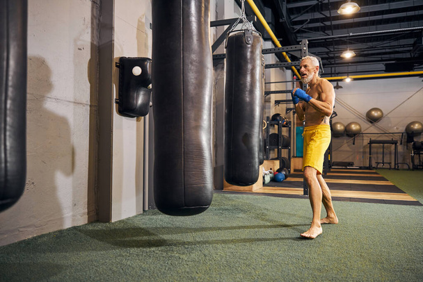 Determined male athlete starting his kickboxing workout - Photo, image