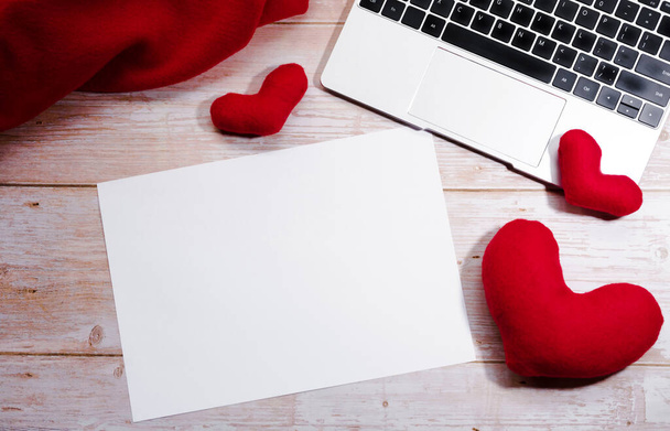 Escriban el deseo sobre el pedazo blanco del papel para el día de San Valentín el 14 de febrero. Celebra el día de San Valentín. Oficina plana con corazones de juguete rojo y teclado negro de la computadora portátil de plata. - Foto, imagen