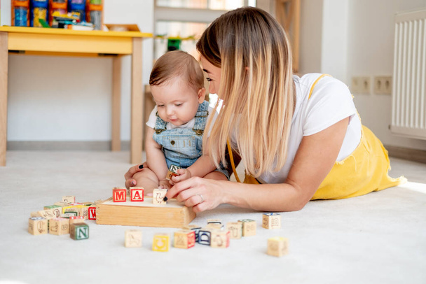 Happy mom and son playing with cubes, early education and development - Zdjęcie, obraz