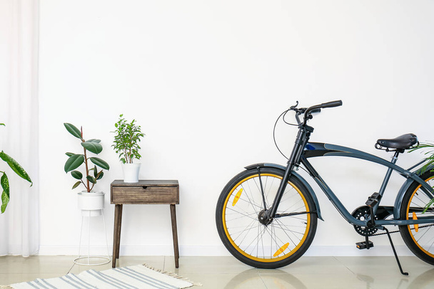 Интерьер современного номера с велосипедом и комнатными растениями - Фото, изображение