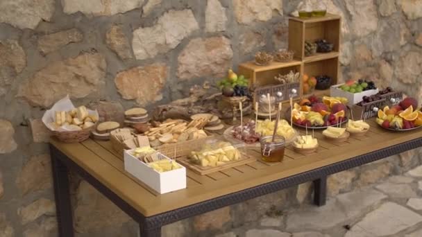 γαμήλιος μπουφές με σνακ φρούτων σε ξύλινο τραπέζι - Πλάνα, βίντεο