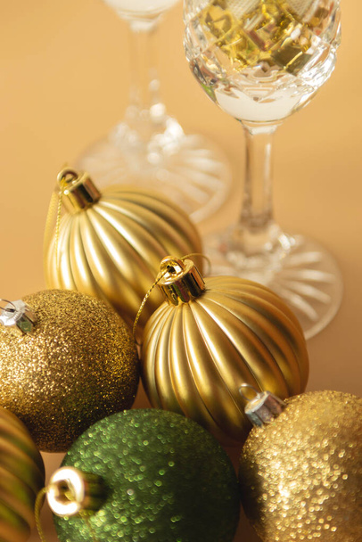 green and gold Christmas baubles on a beige background - Foto, Bild