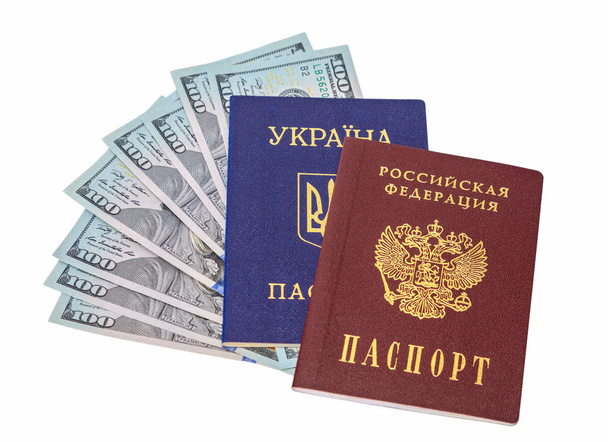 Ukrainian, Russian passports and  dollar bills over white backgr - Photo, Image