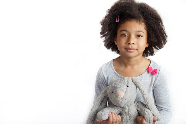 l'adorabile bambina che tiene il simpatico giocattolo del coniglietto in studio - Foto, immagini