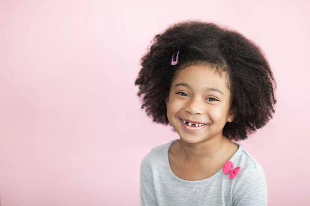 retrato de una niña sonriente con el pelo rizado en el estudio - Foto, imagen