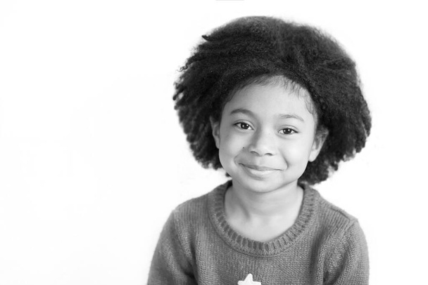черно-белая фотография маленькой девочки, улыбающейся перед камерой  - Фото, изображение