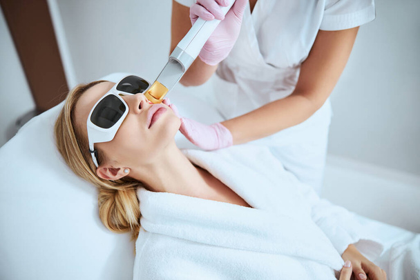 Woman undergoing the fractional laser skin treatment - Photo, Image