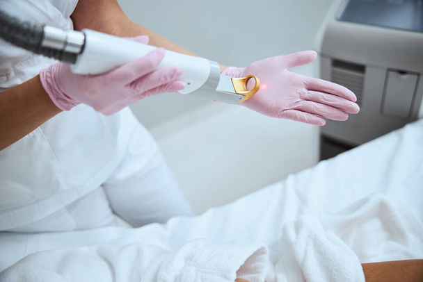 Dermatologist testing the beauty device before the procedure - Foto, Imagem