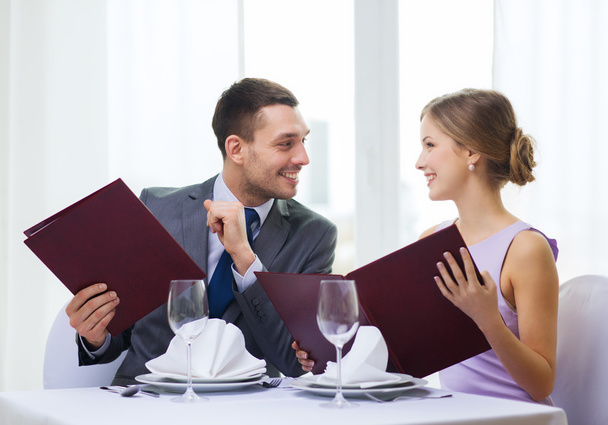 Smiling couple with menus at restaurant - Zdjęcie, obraz
