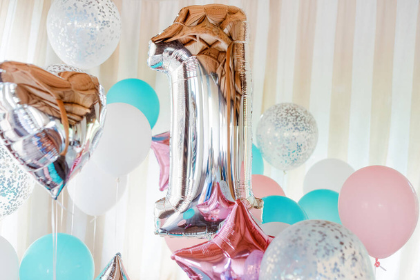 Ballons gonflables roses, argentés et bleus sur rubans - numéro 1. Décorations pour fête d'anniversaire. Ballon design métallique. - Photo, image