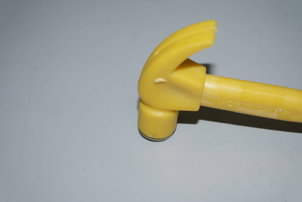 Selectief gericht, close-up zicht van speelgoed hamer gemaakt van kunststof geplaatst op metalen achtergrond - Foto, afbeelding