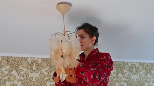 Young girl rub the chandelier from dust. House cleaning - Footage, Video