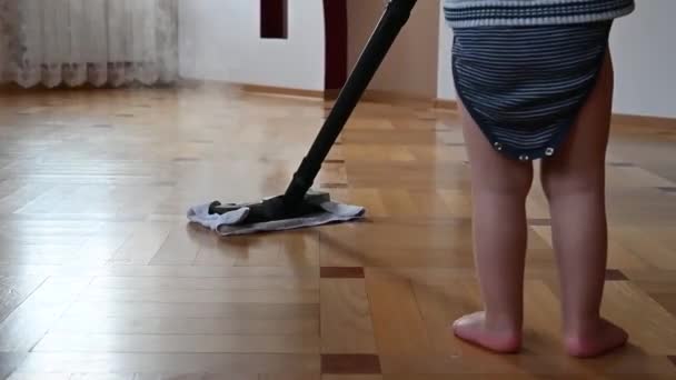 the child washes the floor with a steam generator - Materiał filmowy, wideo