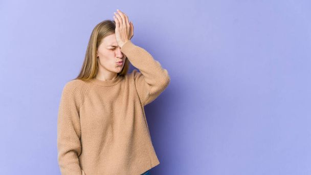 Young blonde woman isolated on purple background forgetting something, slapping forehead with palm and closing eyes. - Photo, Image