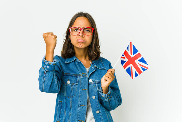 Junge lateinamerikanische Frau mit einer englischen Flagge auf weißem Hintergrund, die Faust in die Kamera zeigt, aggressiver Gesichtsausdruck. - Foto, Bild
