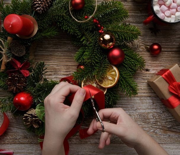 Christmas home decoration, female hands holding a wreath, hand made - Foto, Imagem