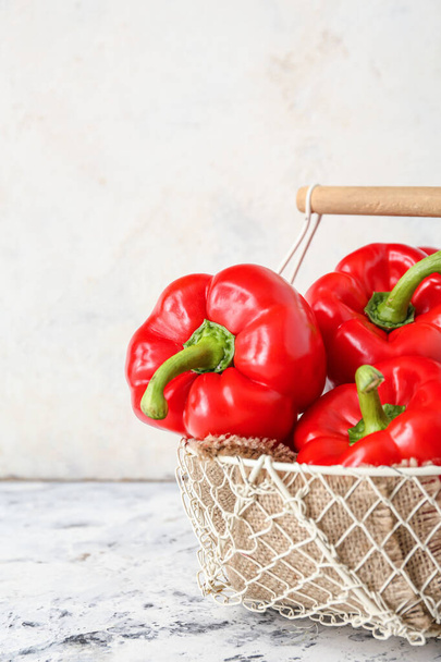 Red bell pepper in wicker basket on table - Fotó, kép