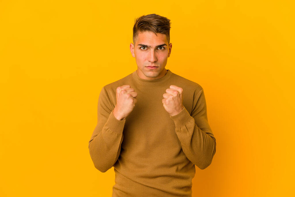 Young handsome caucasian man isolated showing fist to camera, aggressive facial expression. - Photo, Image
