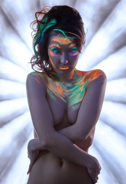 Naked young woman posing with glowing neon makeup - Фото, зображення