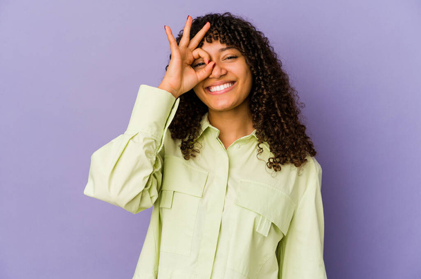 Mladý africký americký afro žena izolovaný vzrušený vedení ok gesto na oko. - Fotografie, Obrázek