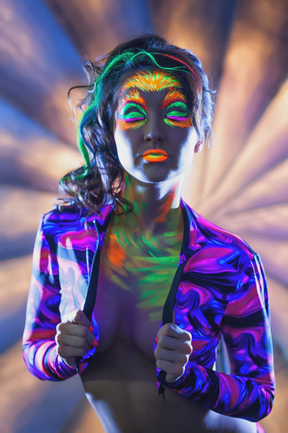 Portrait of attractive woman with UV disco make-up - 写真・画像