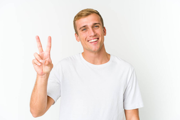 Young caucasian handsome man showing victory sign and smiling broadly. - Fotoğraf, Görsel