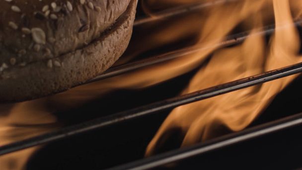 Processus de cuisson du pain avec grille et feu ouvert, recette traditionnelle. Images d'archives. Gros plan des tiges de grill en métal et de la flamme de feu à l'intérieur du four avant la cuisson des aliments. - Photo, image