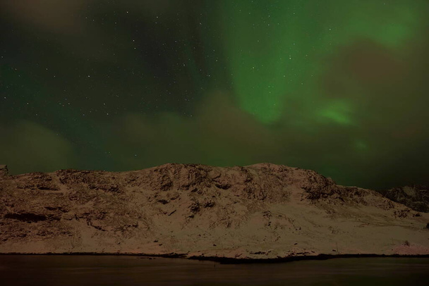 Aurora borealis Green northern lights above mountains - Foto, Imagem