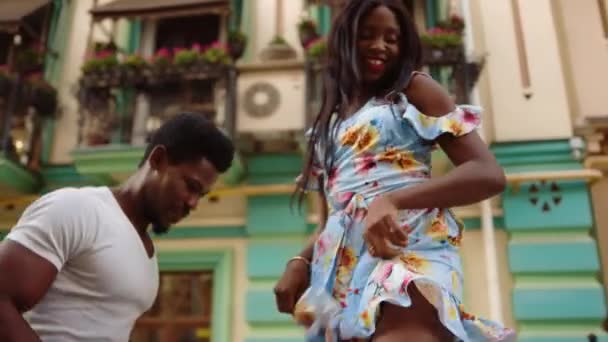 Gülümseyen afro kadın sokakta hareket ediyor. Dansçılar Latin dansı yapıyor - Video, Çekim