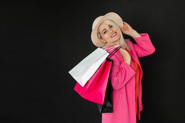 Mujer de compras sosteniendo bolsas, aisladas sobre fondo negro. concepto de viernes negro - Foto, Imagen