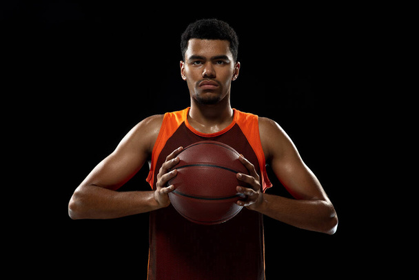 Young african basketball player training on black studio background. - Foto, Bild