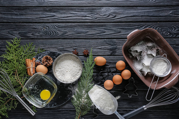 Ingredienti per pasticceria natalizia e utensili da cucina su sfondo di legno scuro - Foto, immagini