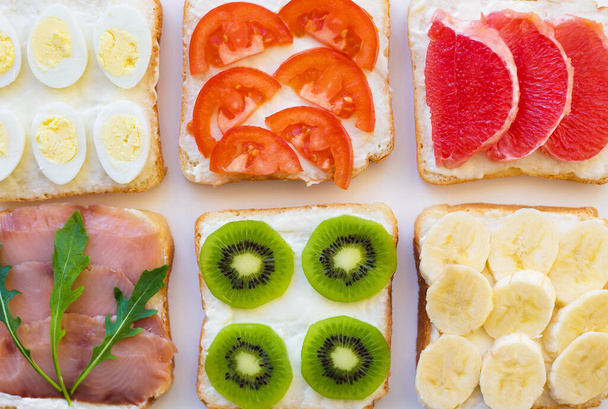 világos keveréke szendvicsek reggeli gyümölcs, zöldség, hal - Fotó, kép