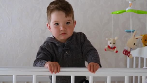 1-2 year old baby having fun in the crib at home - Materiał filmowy, wideo