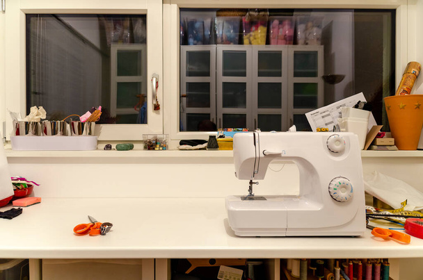 Dikiş makinesi ve bazı aletleri olan bir kadın terzinin çalışma masası. - Fotoğraf, Görsel