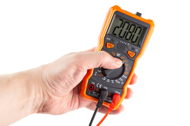 digit 2080 on lcd screen of digital electrical multimeter in left caucasian hand, isolated on white background - Photo, Image