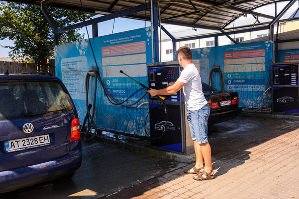 Iwano-Frankowsk, Ukraina 14 sierpnia 2020: człowiek w samoobsługowej myjni samochodowej.2020 - Zdjęcie, obraz
